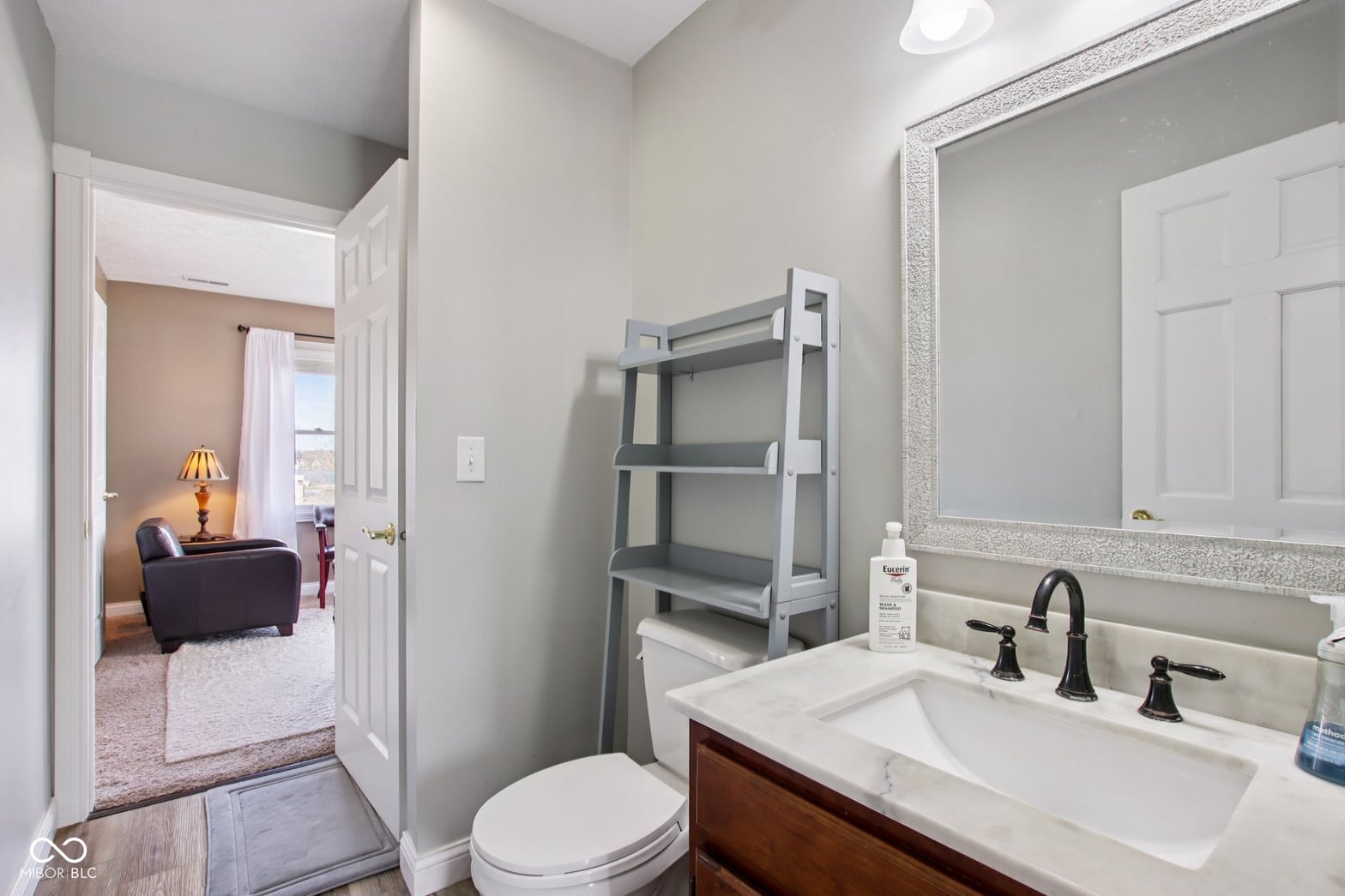 Updated primary bath with marble countertops and elegant fixtures.