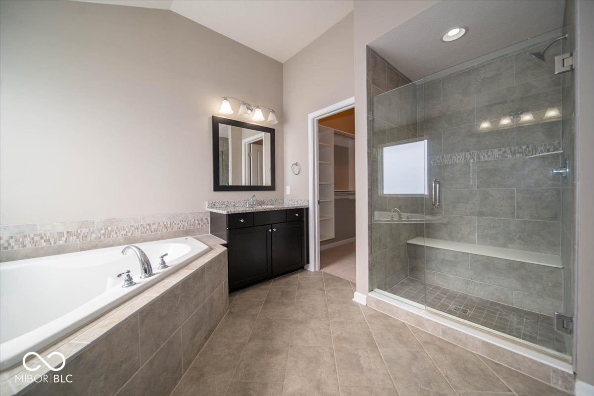 Luxurious primary bath with frameless shower and soaking tub.