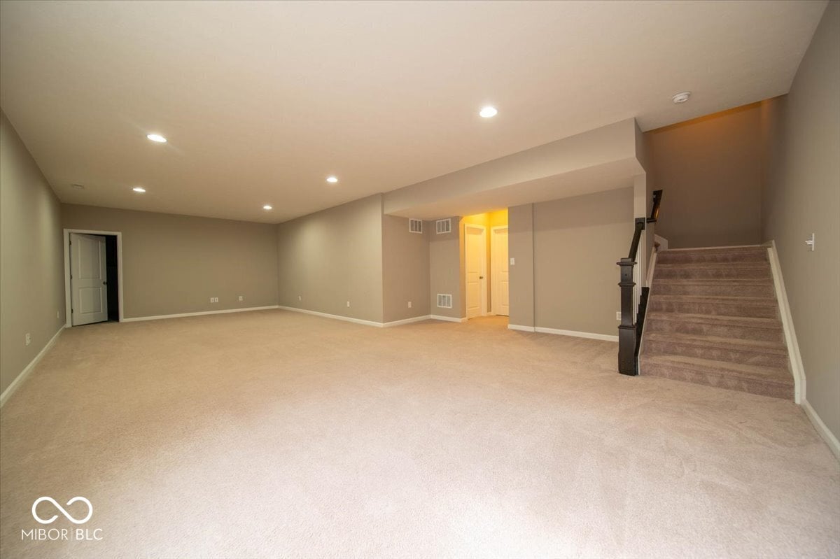 Spacious finished basement with modern lighting and storage.