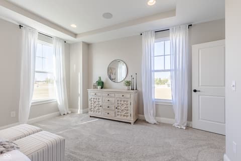 Primary bedroom at 15732 Showdown Road, Noblesville, IN — Bright primary suite with tray ceiling and dual windows.