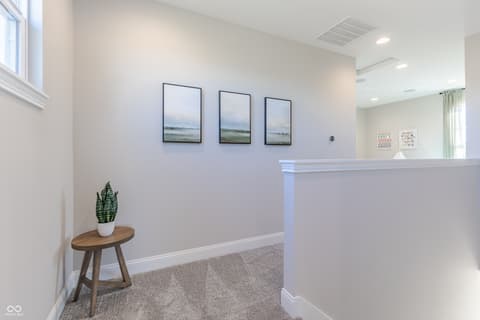 Hallway at 15732 Showdown Road, Noblesville, IN — Bright hallway with elegant wainscoting and natural light.