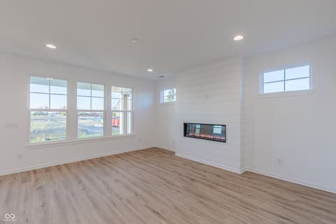 Living room at 15752 Showdown Road, Noblesville, IN — Bright modern living room with linear fireplace and views.