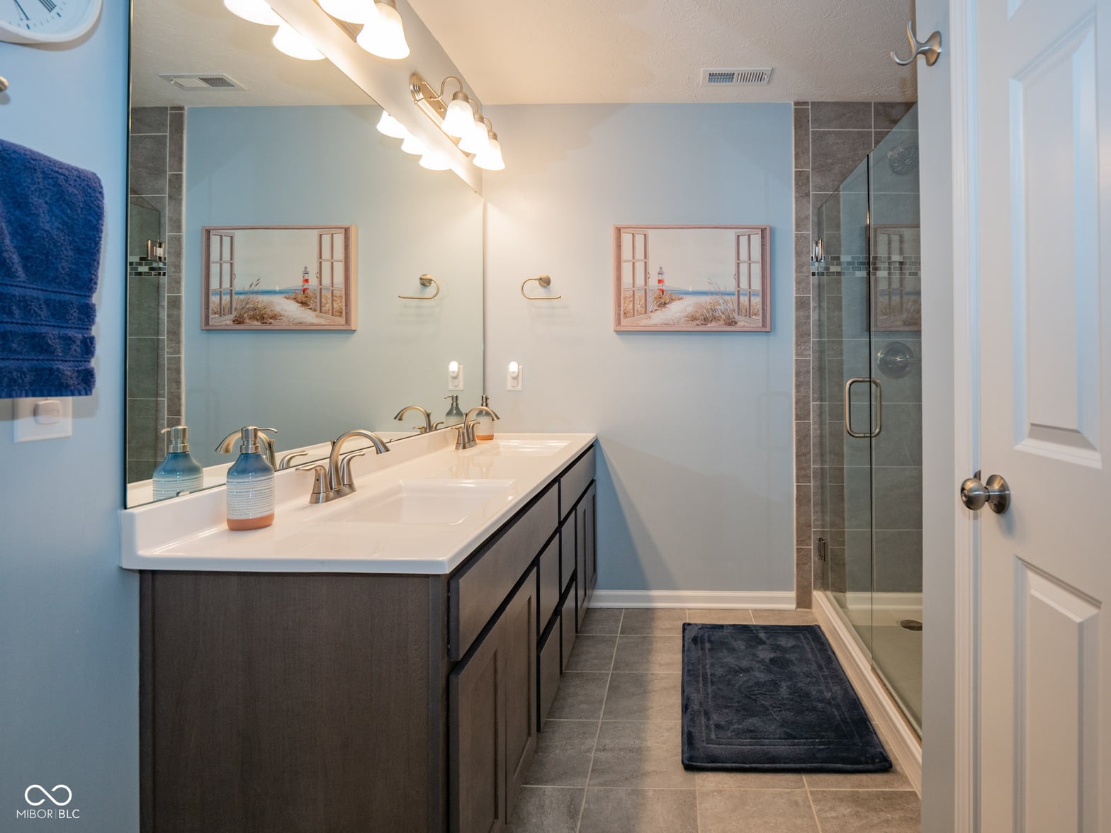 Modern spa-like primary bath with dual vanity and walk-in shower.