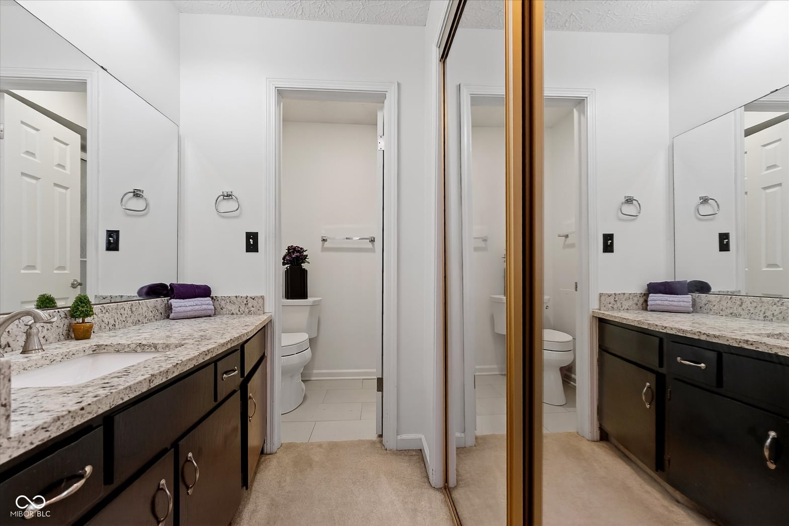 Spa-like primary bath with dual granite vanities and ample storage.