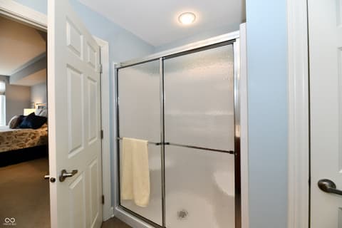 Primary bathroom at 20971 Shoreline Court, Noblesville, IN — Updated primary bathroom with modern sliding glass shower.