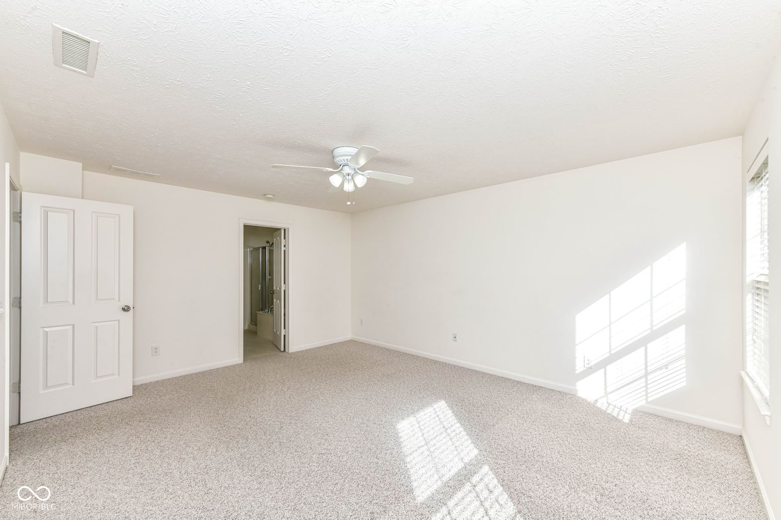 Bright spacious primary bedroom with abundant natural light.