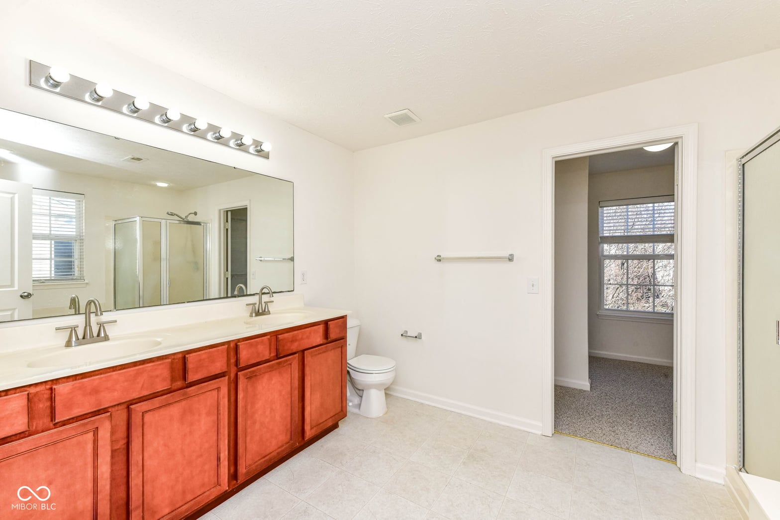 Spacious primary bath with dual vanity and walk-in closet.