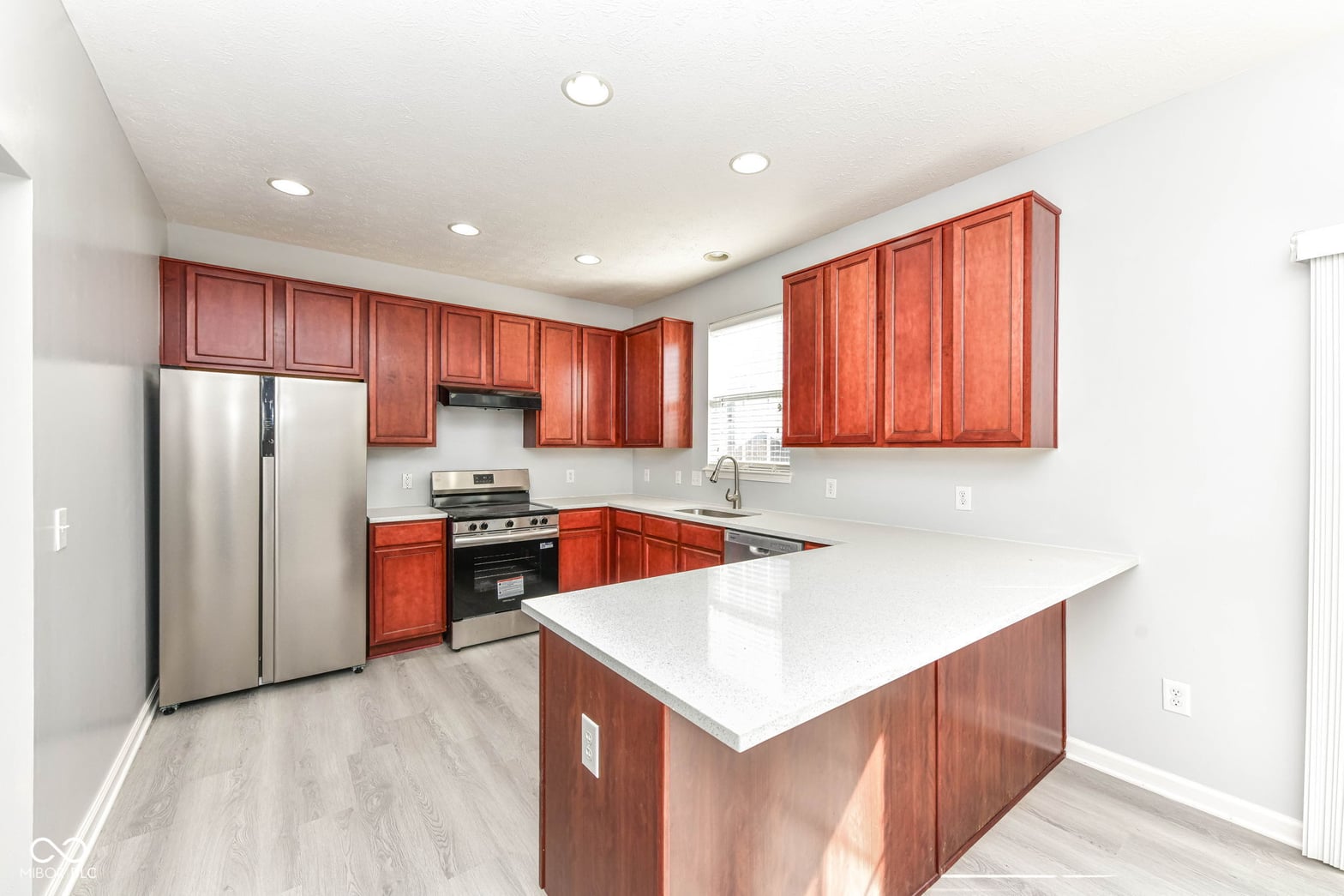 Updated kitchen with cherry cabinets and quartz counters.
