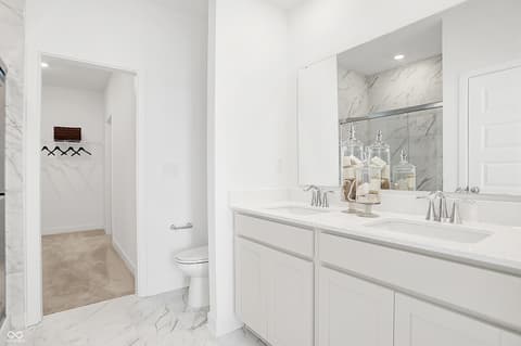 Primary bathroom at 15498 Postman Road, Fishers, IN — Luxurious primary bath with marble finishes and dual vanity.