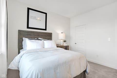 Primary bedroom at 15498 Postman Road, Fishers, IN — Bright, modern primary bedroom with wood accents.