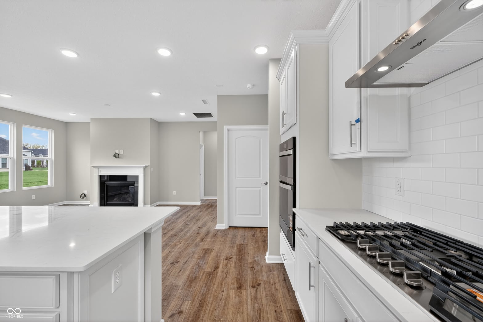 Bright modern kitchen with gas range and quartz island.