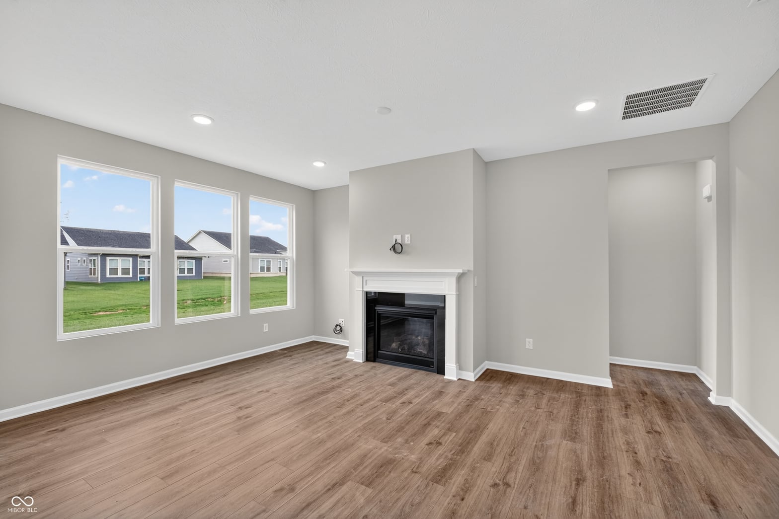 Bright living room with fireplace and abundant natural light.