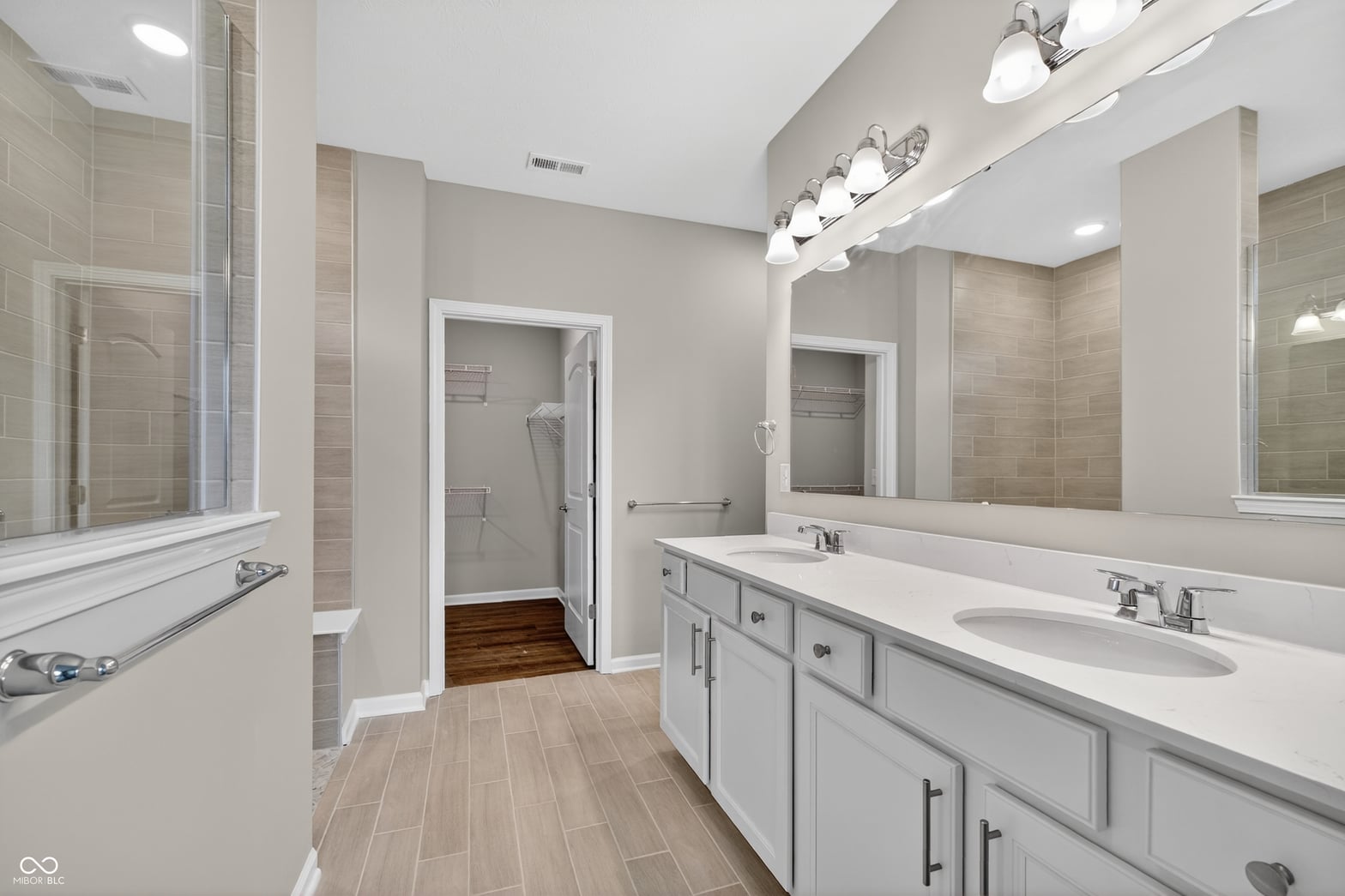 Luxurious primary bath with double vanity and frameless shower.