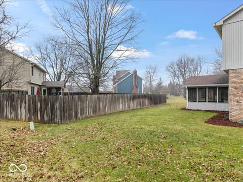 Yard at 792 Grace Drive, Carmel, IN — Spacious fenced backyard with mature trees and flat terrain.
