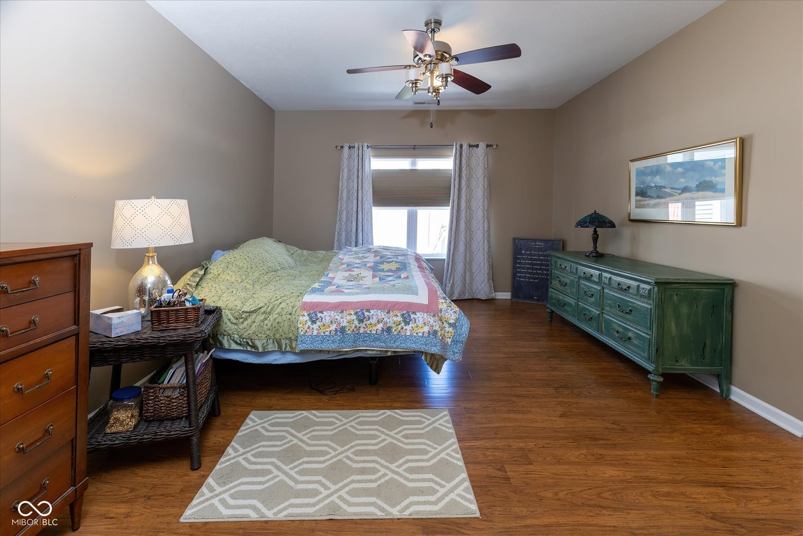 Spacious bedroom with hardwood floors and glass doors.