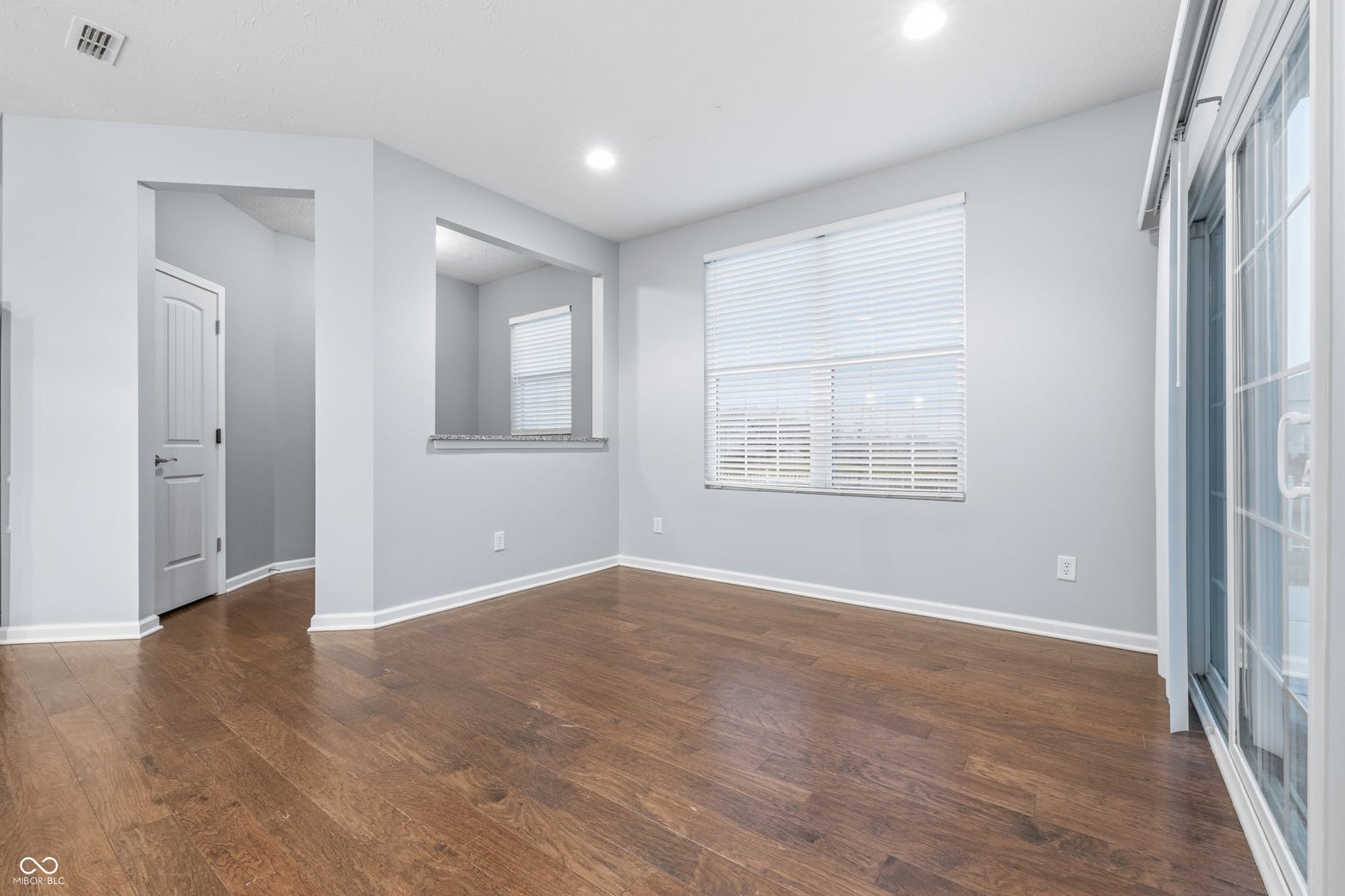 Bright primary bedroom with hardwood floors and plenty of natural light.