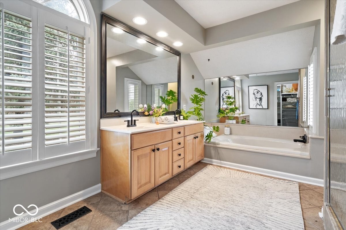 Luxurious primary bath with dual vanity and soaking tub.