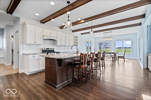 Kitchen at 16540 Shore Oaks Court, Noblesville, IN — Spacious kitchen with exposed beams and granite island.