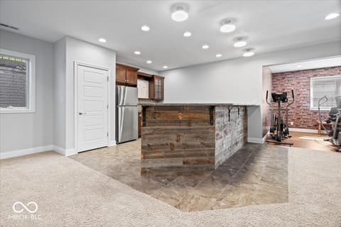 Basement at 16540 Shore Oaks Court, Noblesville, IN — Luxurious finished basement with wet bar and gym space.