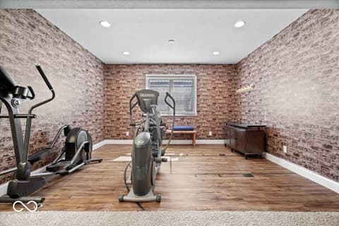 Bonus room at 16540 Shore Oaks Court, Noblesville, IN — Stunning brick home gym with natural light and equipment.