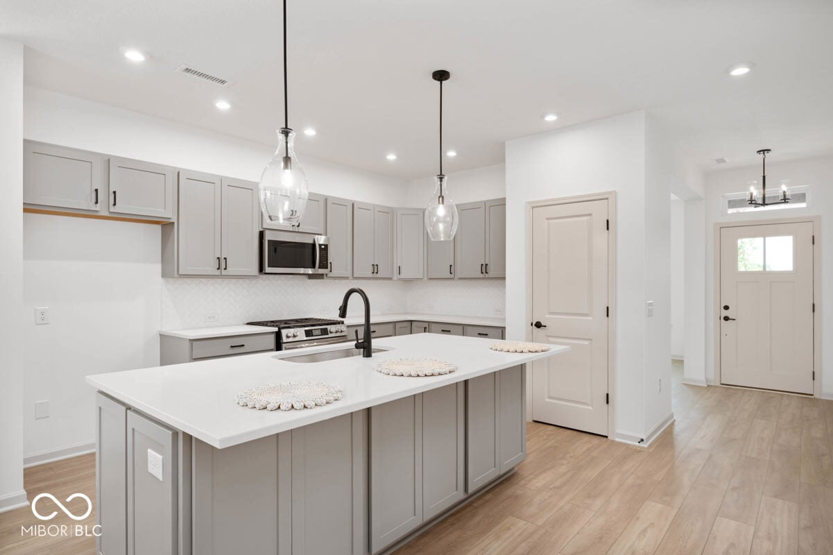 Bright contemporary kitchen with large island and pendant lights.