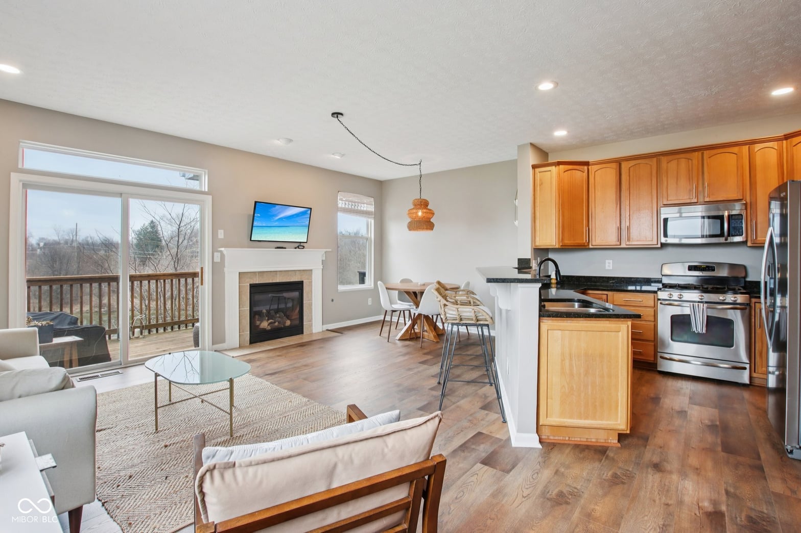 Spacious open-concept family room with fireplace and kitchen.