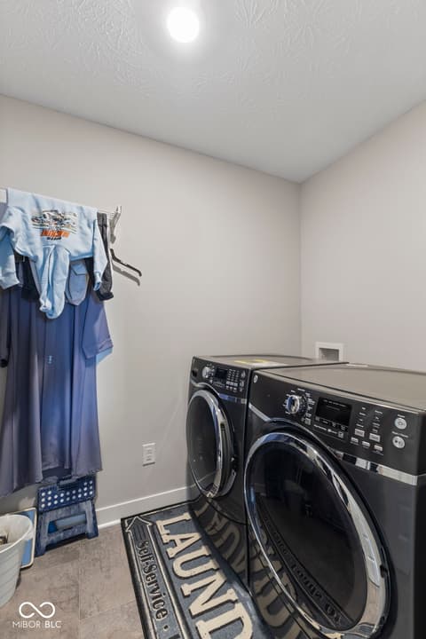 Laundry room at 16352 Sedalia Drive, Fishers, IN — Modern laundry room with black front-load washer and dryer.