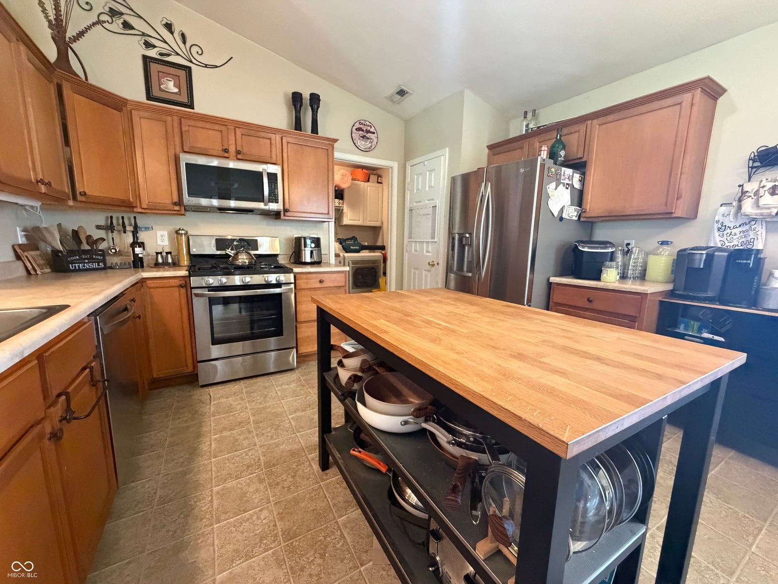 Spacious kitchen with island and stainless steel appliances.
