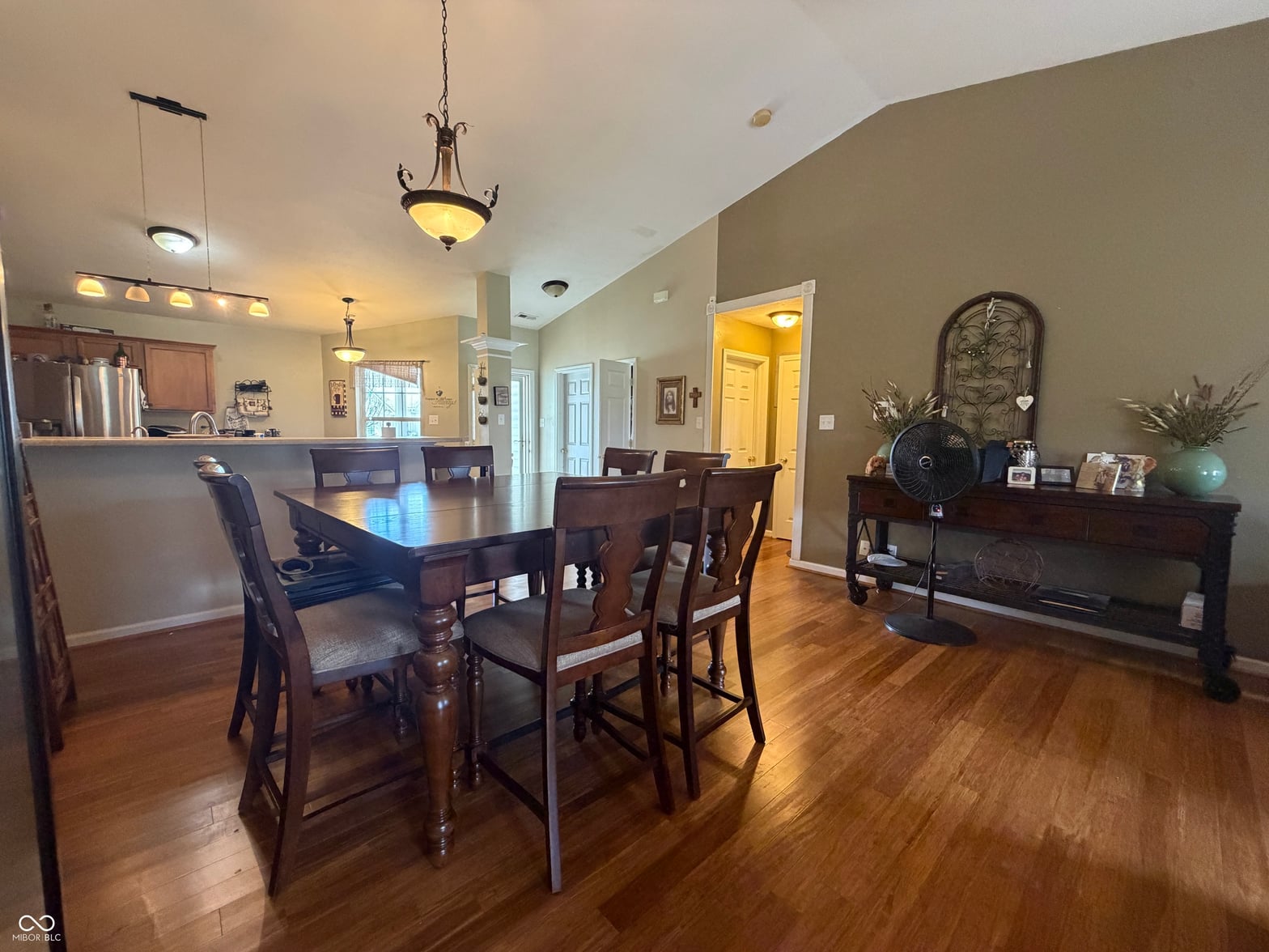 Open dining area with hardwood floors and modern lighting.