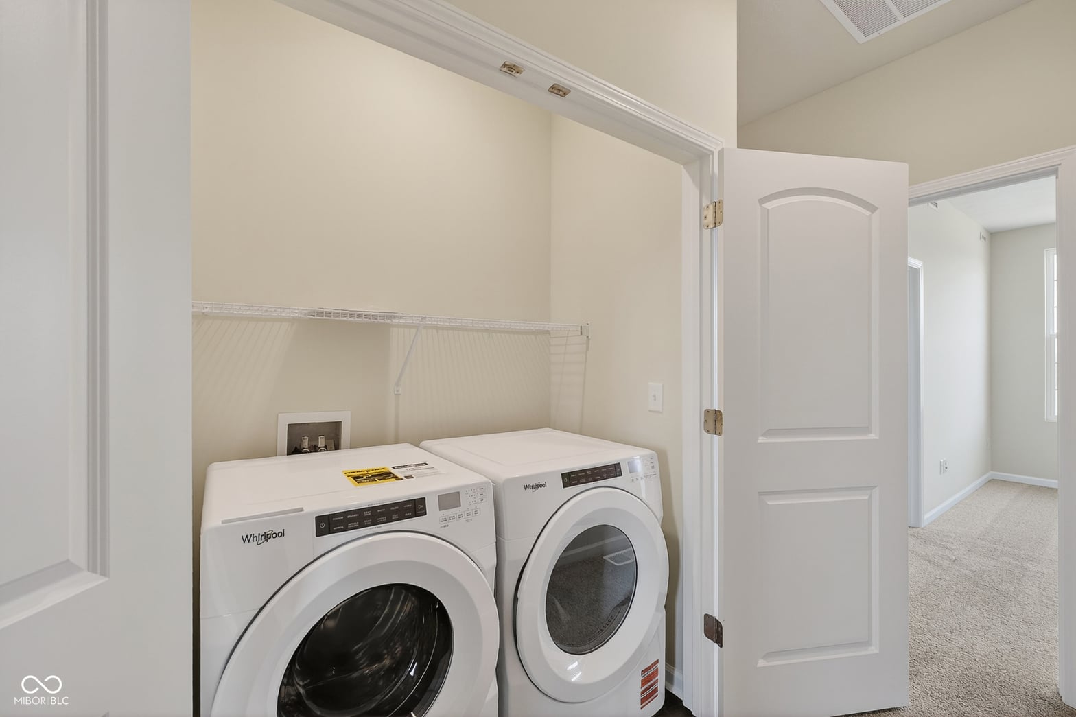 Dedicated laundry room with new Whirlpool washer and dryer.