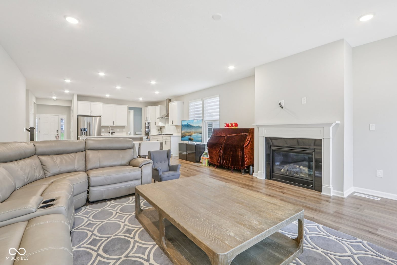 Spacious open-concept living with fireplace and modern finishes.