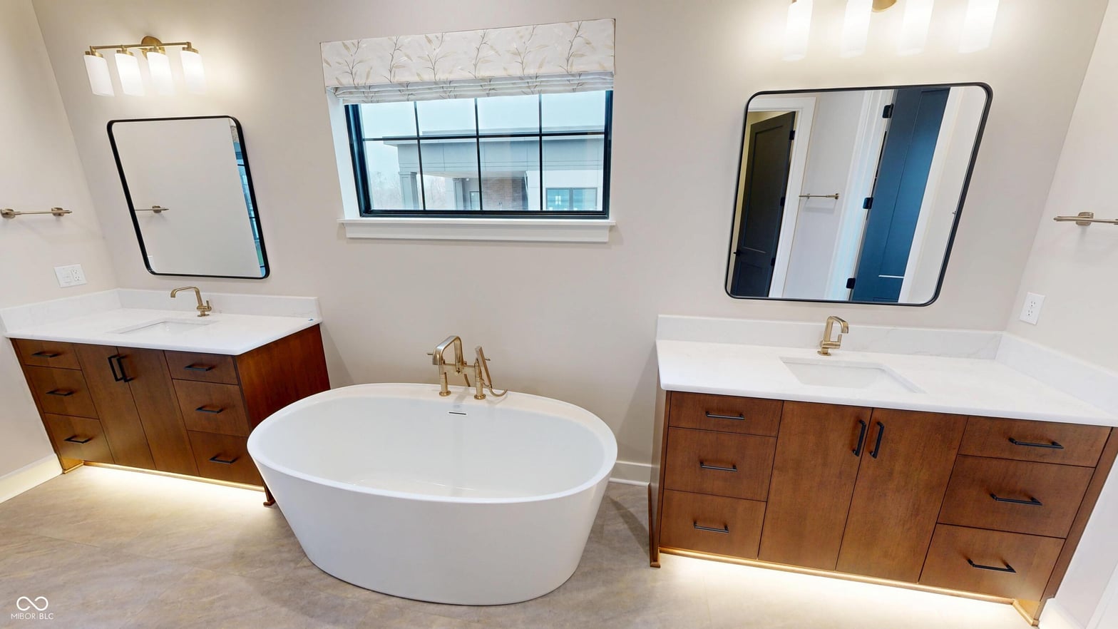 Luxurious spa-like primary bath with freestanding tub and dual vanities.