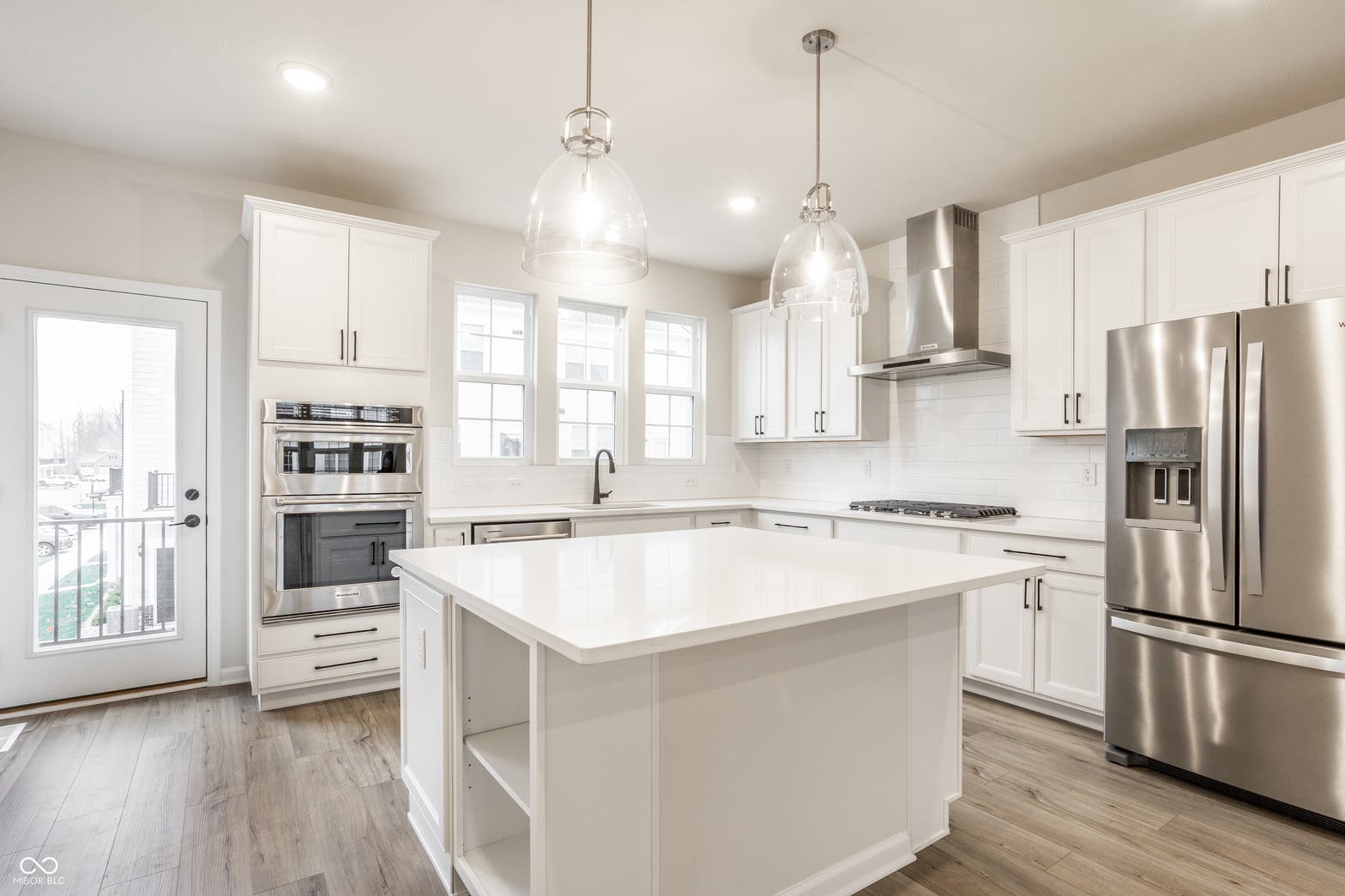 Bright modern kitchen with white cabinetry and stainless steel.