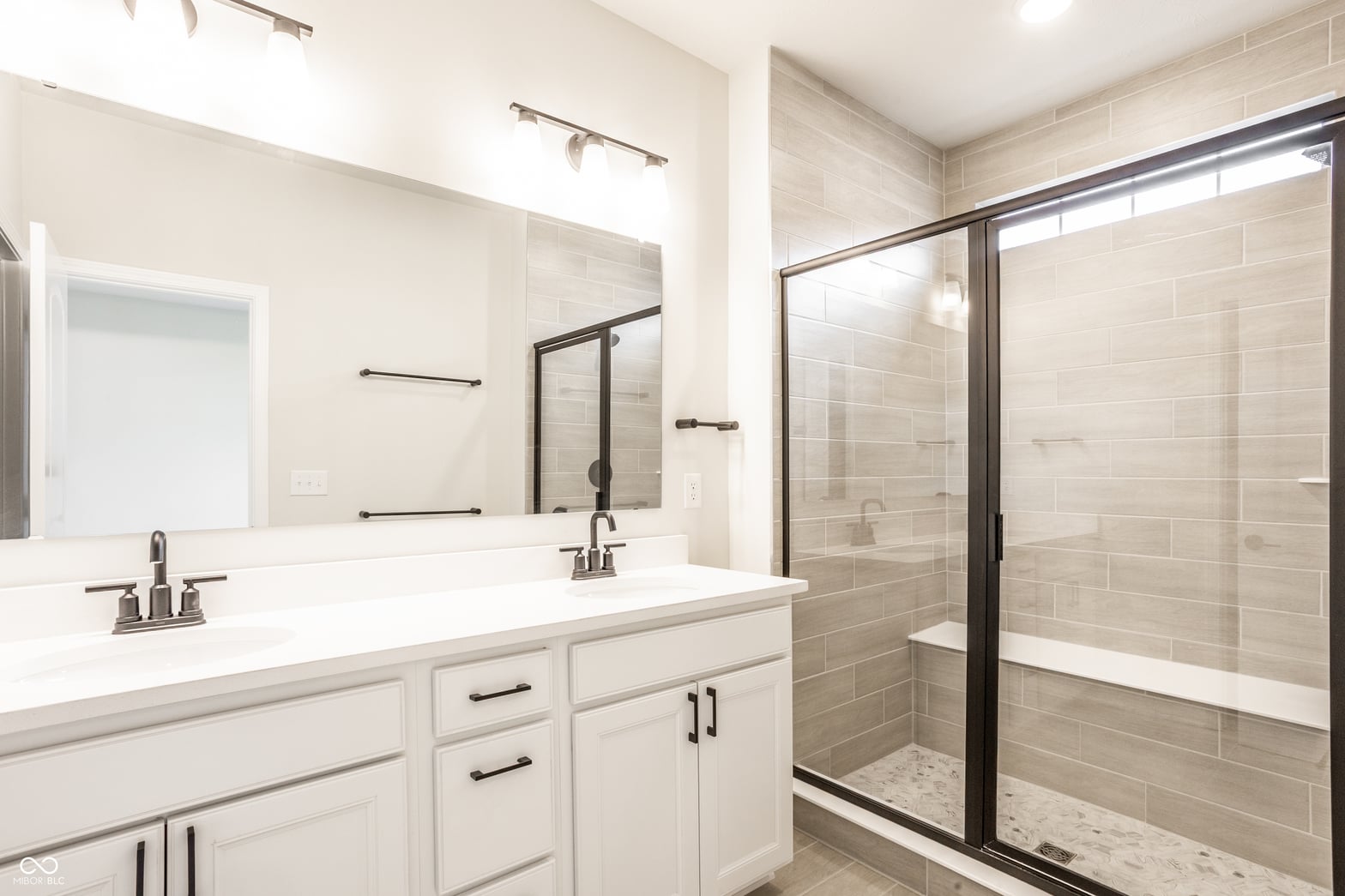 Luxurious primary bath with dual vanity and walk-in shower.