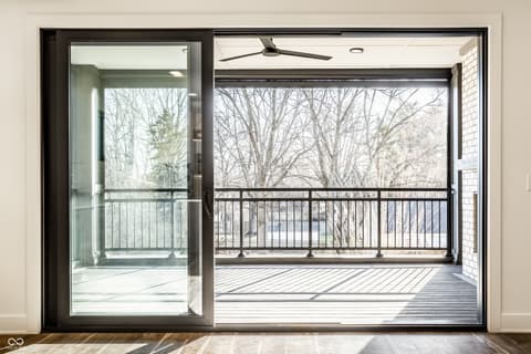 Outdoor living area at 717 Livingstone Drive, Carmel, IN — Expansive modern deck with glass doors and tree views.