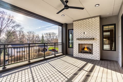 Outdoor living area at 717 Livingstone Drive, Carmel, IN — Stunning covered deck with fireplace and panoramic views.
