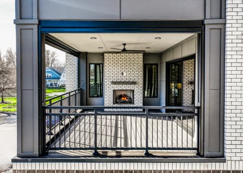 Outdoor living area at 717 Livingstone Drive, Carmel, IN — Stunning screened porch with fireplace and modern design.