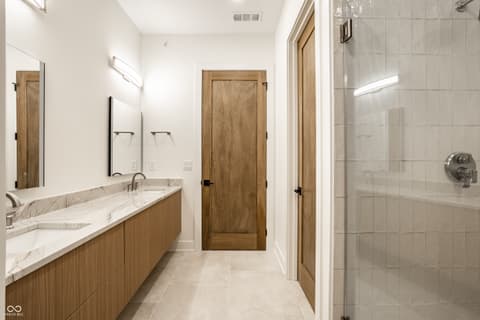 Primary bathroom at 717 Livingstone Drive, Carmel, IN — Luxurious primary bath with marble counters and spa shower.