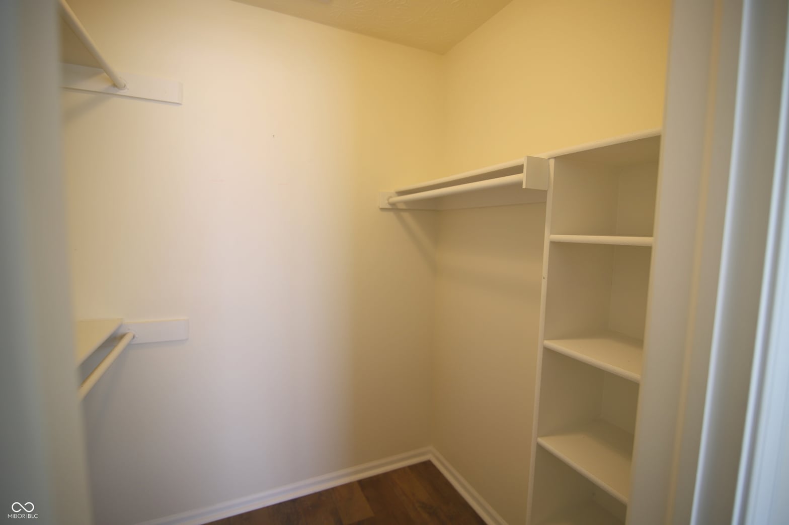 Spacious walk-in closet with built-in shelving.