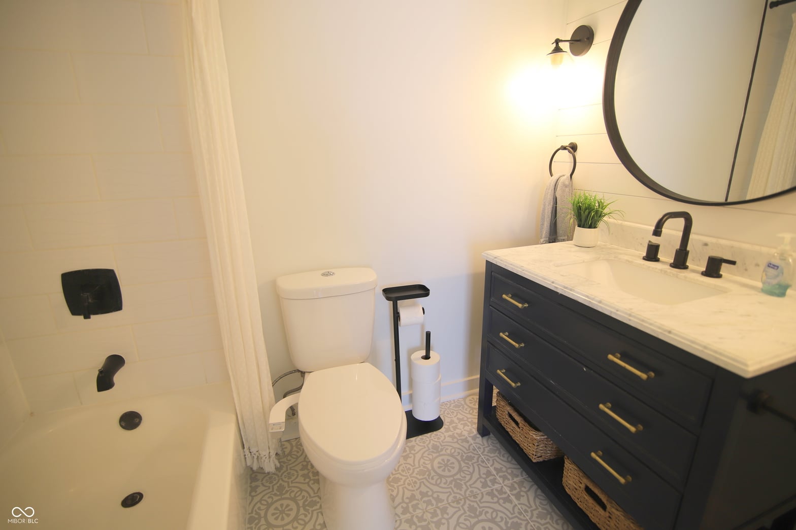 Modern primary bath with marble countertop and black vanity.