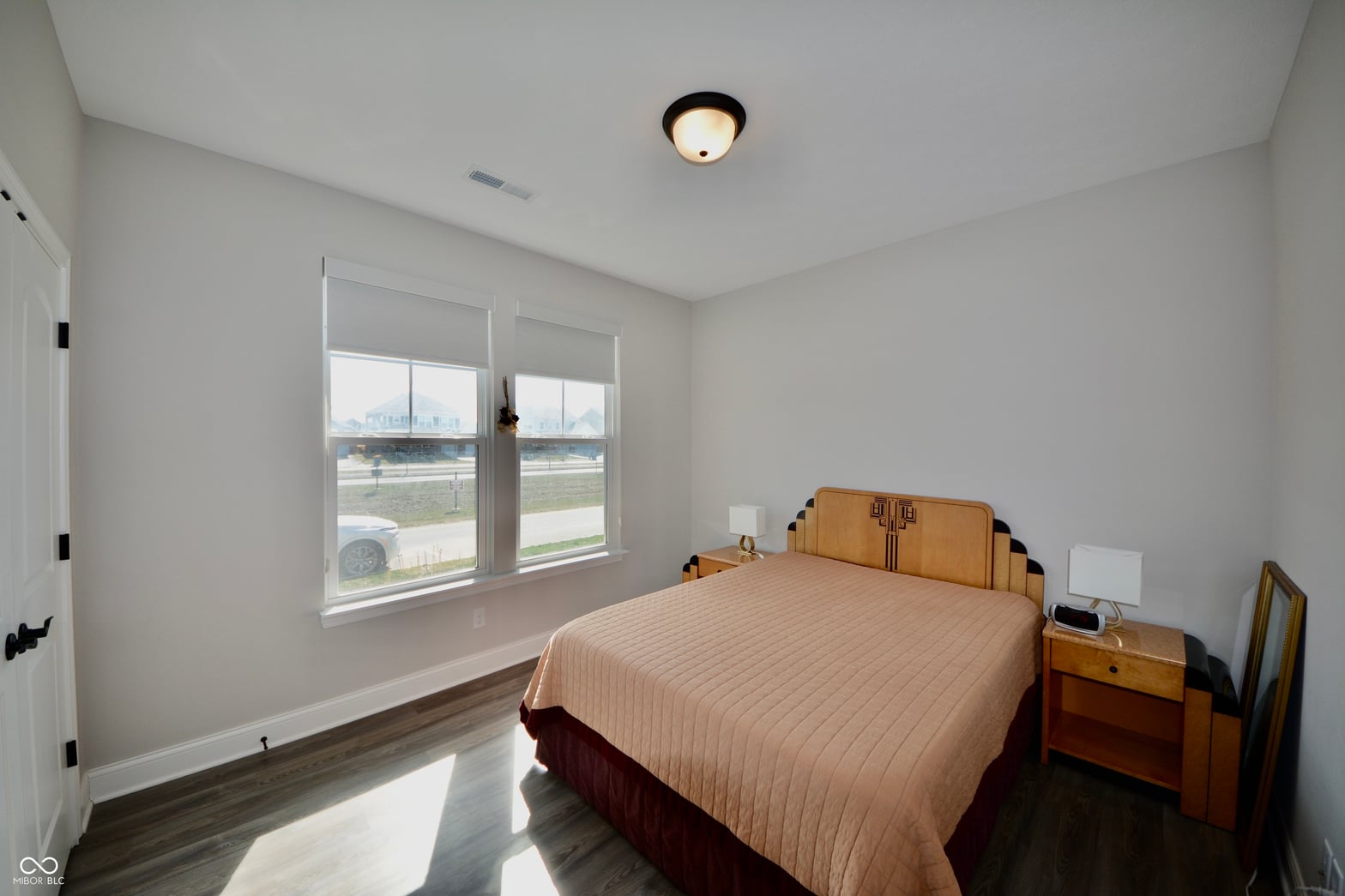 Bright primary bedroom with expansive windows and water views.