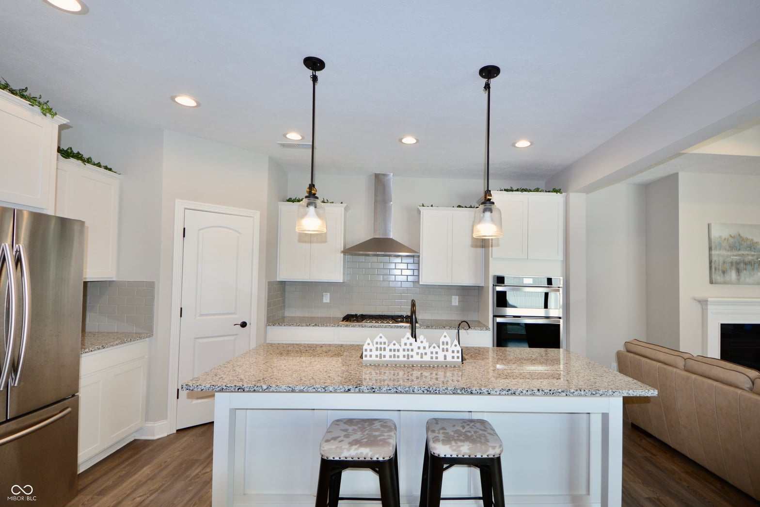 Modern kitchen with granite island and premium stainless appliances.