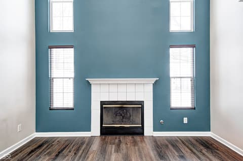Living room at 12673 Ladson Street, Fishers, IN — Bright living room with fireplace and teal accent wall.