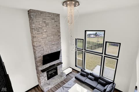 Living room at 3565 Snowdon Drive, Westfield, IN — Stunning modern living room with soaring brick fireplace.