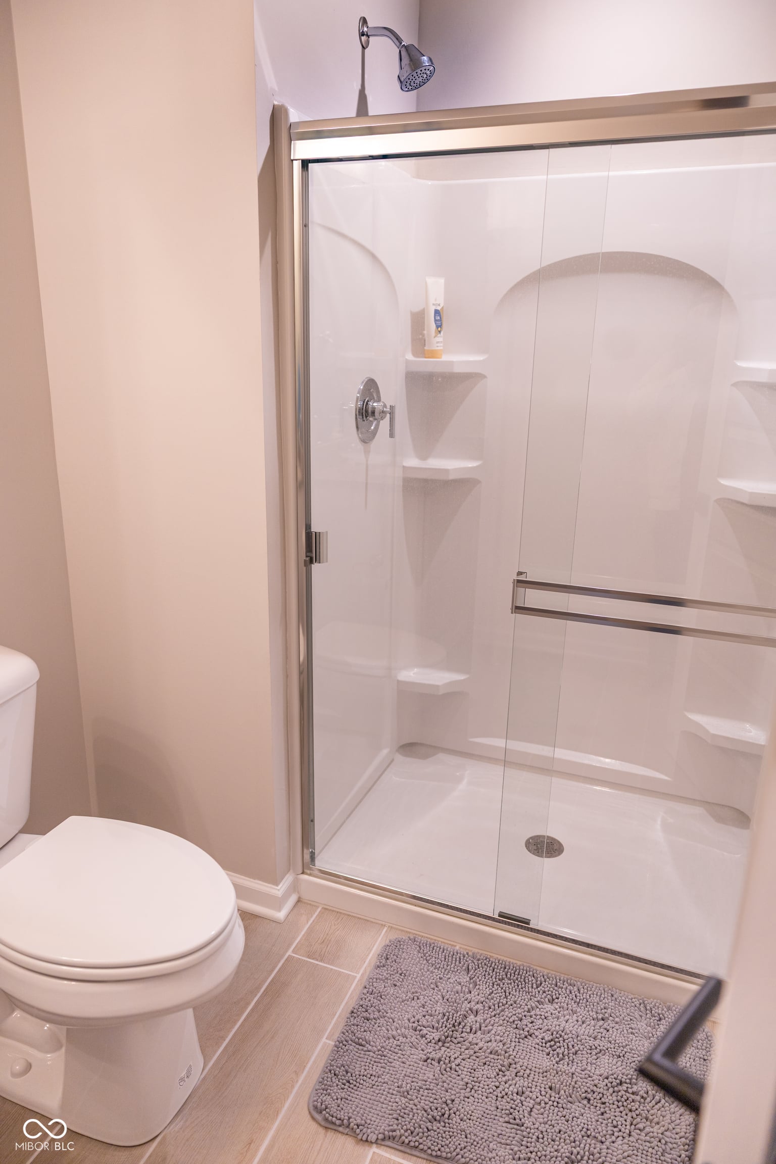 Modern frameless shower with built-in storage shelves.