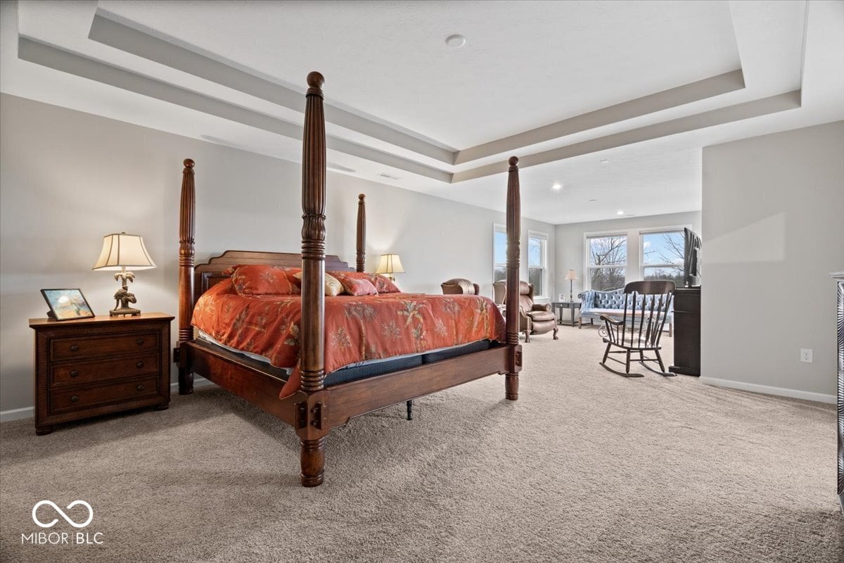 Luxurious primary suite with coffered ceilings and sitting area.