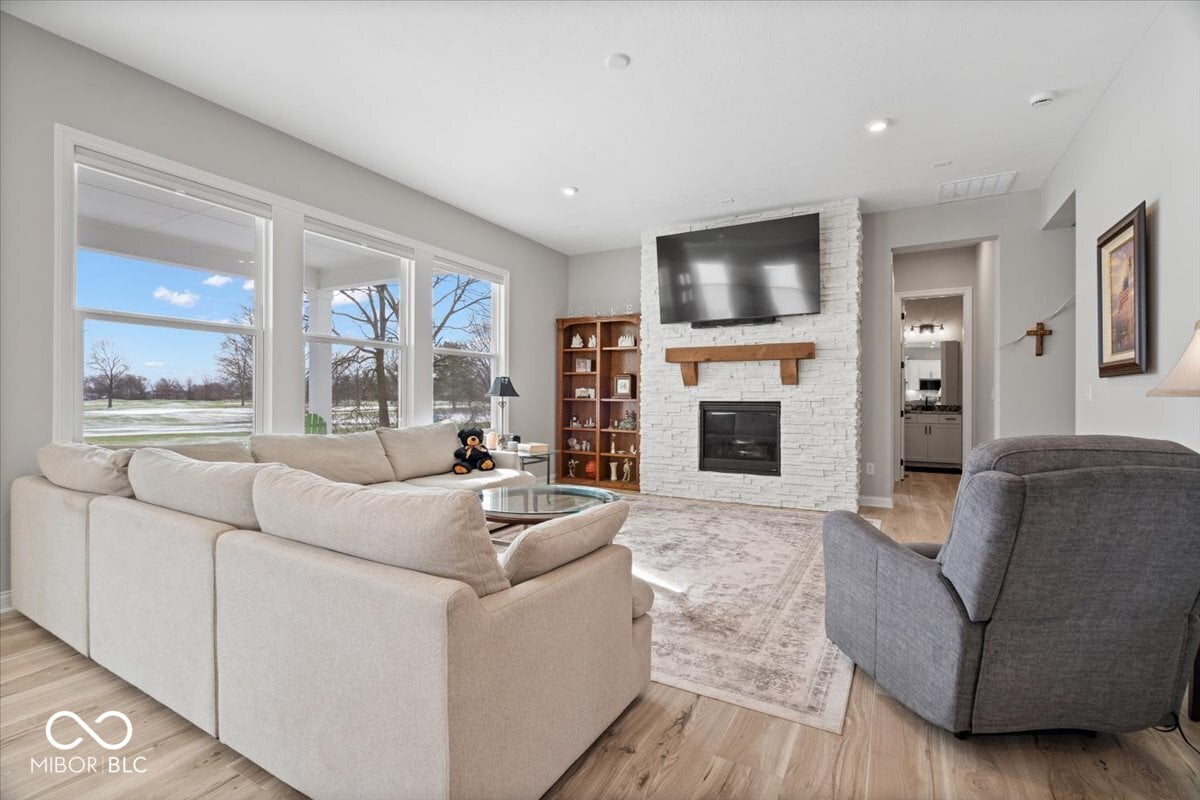 Bright contemporary living room with white brick fireplace and large windows.