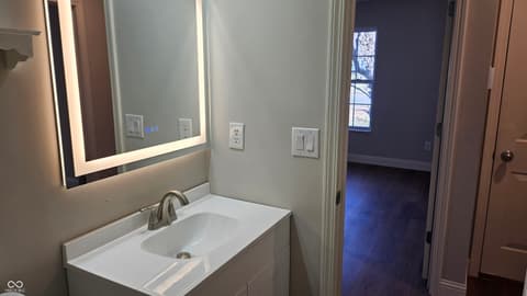 Primary bathroom at 18702 Planer Drive, Noblesville, IN — Modern primary bath with LED-backlit mirror and vanity.