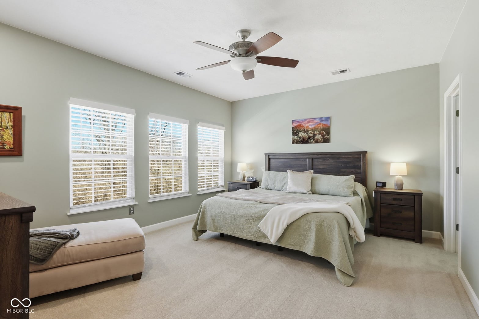 Spacious primary bedroom with plantation shutters and natural light.