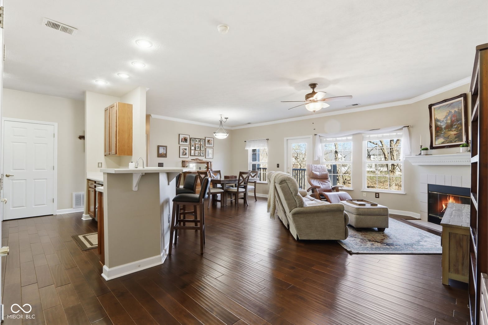 Bright open-concept living with fireplace and hardwood floors.
